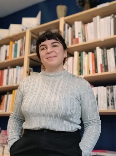 Photo d'Amandine devant un rayon de livres.